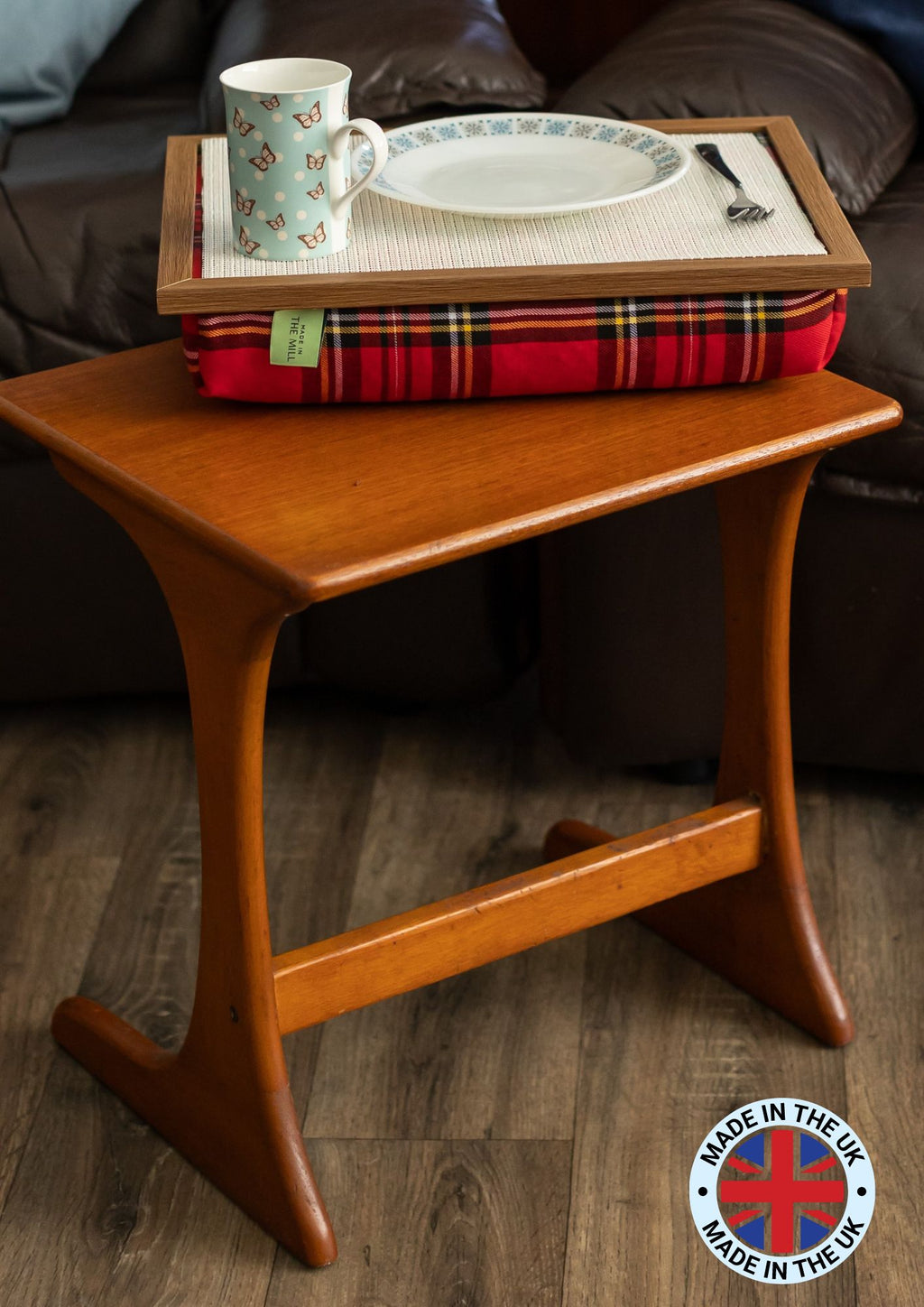 The Royal Stewart Red Tartan Lap Tray on a wooden coffee table in a living room