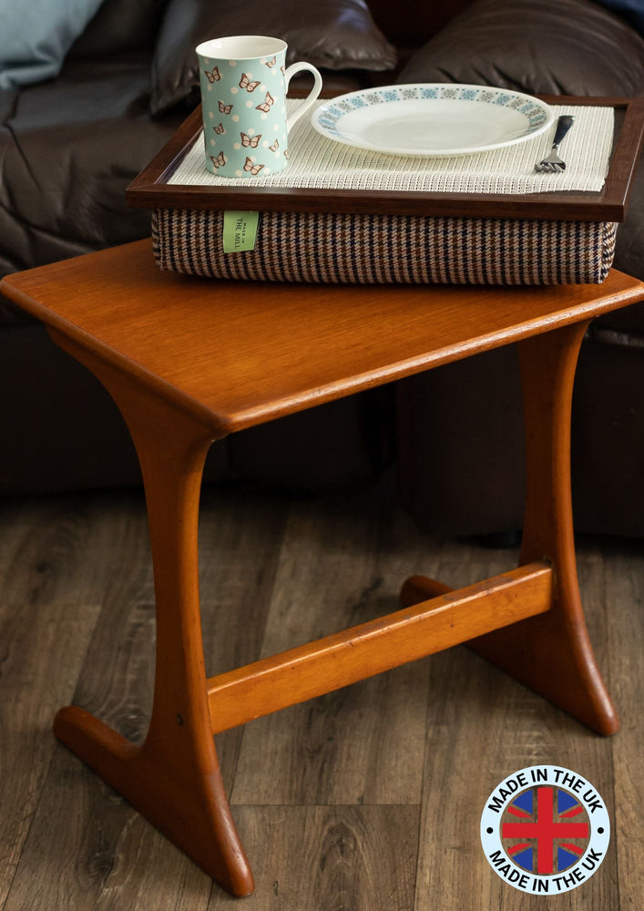 The luxury dogtooth lap tray with bean bag on a wooden table in a living room with a 'made in the UK' logo in the bottom right hand corner.