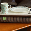 The luxury Dogtooth Lap Tray with bean bag on a table in a living room, with non slip matting, a mug, a plate and a fork on it.