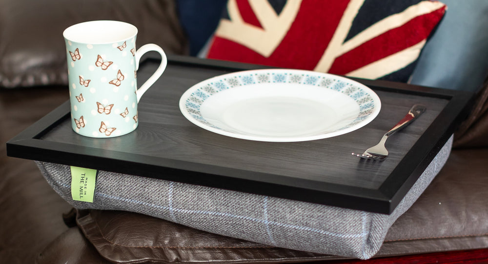The luxury grey tweed lap tray on a sofa with a mug and a plate on it