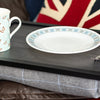 The luxury grey tweed lap tray on a sofa with a mug and a plate on it