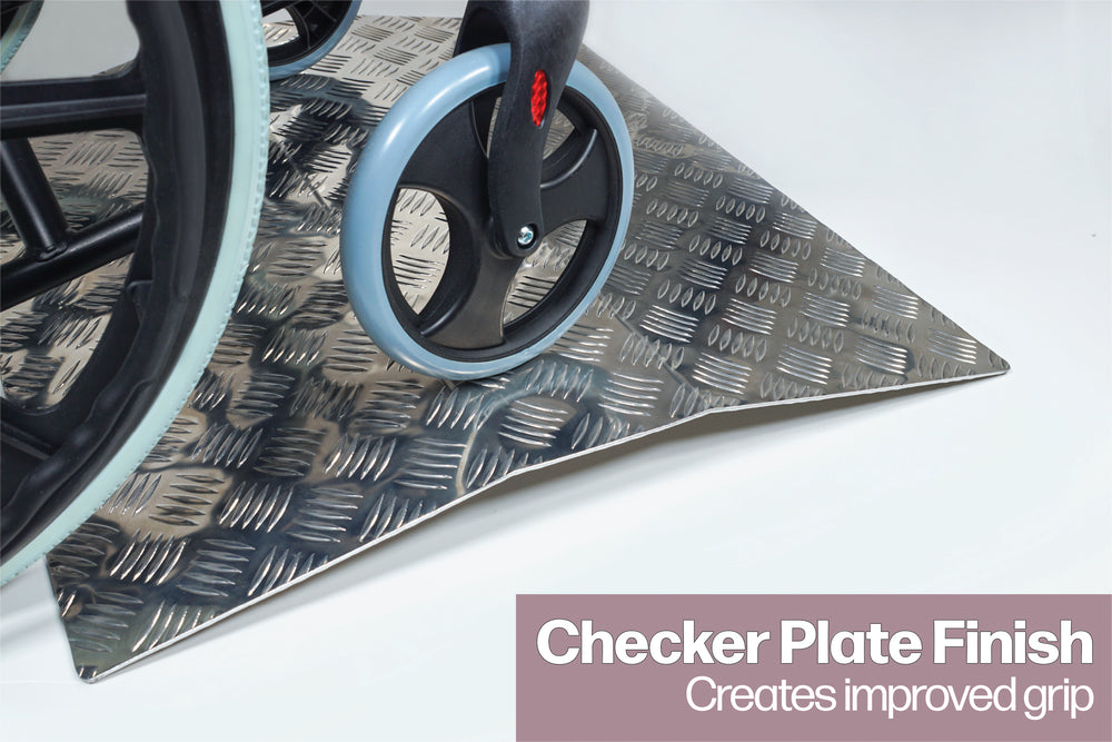 A close up of the wheel on a wheelchair going over an Aluminiu, Threshold Bridging Ramp