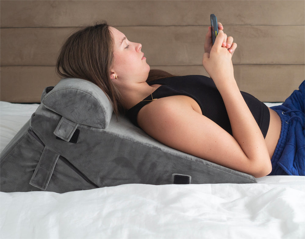 a woman using the bed wedge pillow 