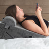 a woman using the bed wedge pillow 