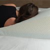 a woman using the bed wedge pillow to sleep