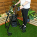 Someone using a black Lightweight Four Wheeled Rollator in a garden