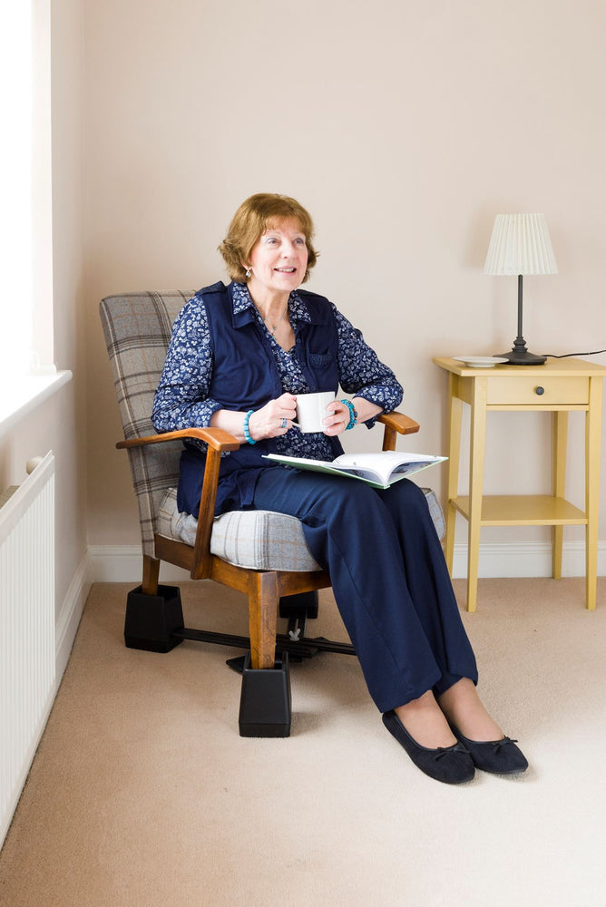 A woman siting in a chair with the Langham Adjustable Chair Raisers