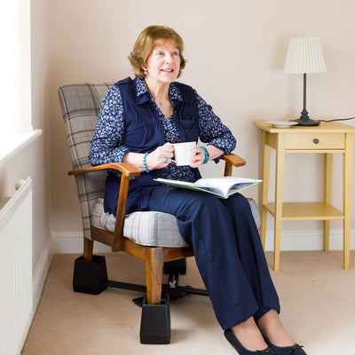 A woman siting in a chair with the Langham Adjustable Chair Raisers