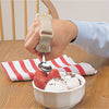 the Built Up Utensil Holder attached to a person's hand and they are using it to eat a bowl of strawberries and ice cream