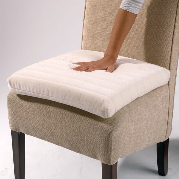 the memory foam seat cushion on a chair with a hand placed on the cushion