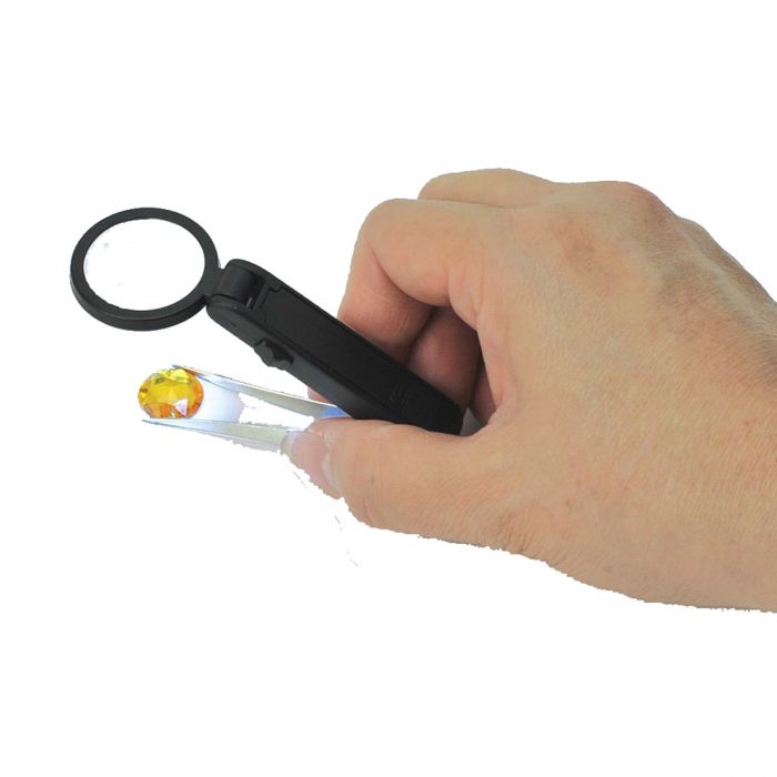 Lifemax Lighted Magnified Tweezers in use, holding small gem