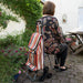 A woman sitting on the seat of the Lifemax 'Take a Seat' Shopping and Leisure Trolley Stair Climber in their garden