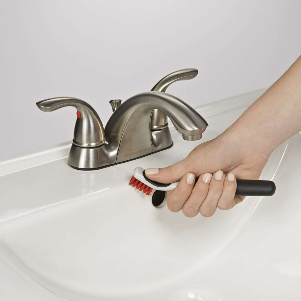 one of the OXO deep clean brushes being used to clean a sink