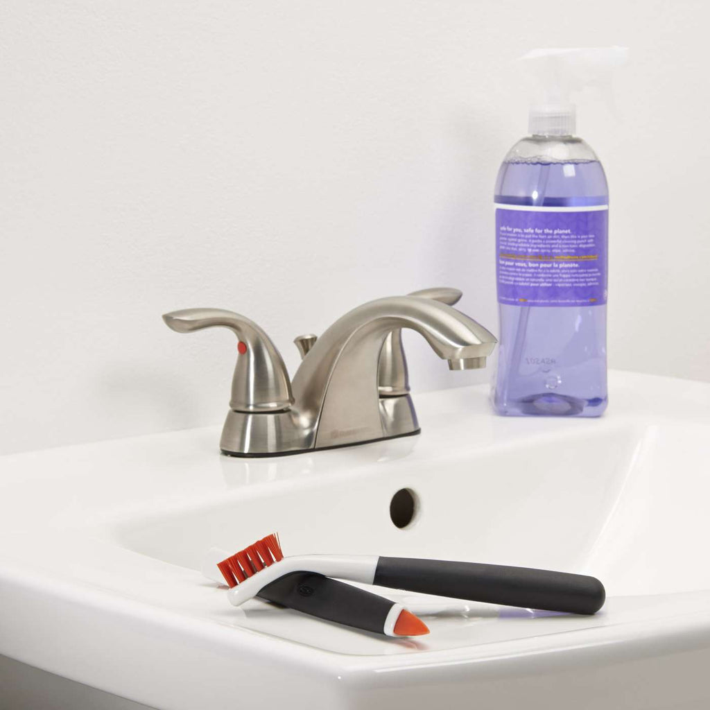 both brushes on the side of a bathroom sink