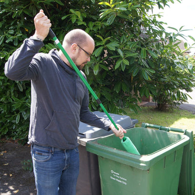 shows a man using the wheelie bin loofah