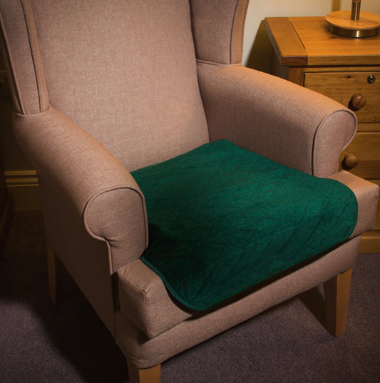 The green coloured Velour Chair Pad on an armchair