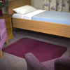 The Maroon Velour Floor Pad on a carpet in a bedroom