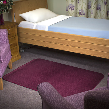 The Maroon Velour Floor Pad on a carpet in a bedroom