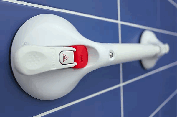close-up image of a Mobeli grab handle fixed to blue tiles, showing safety indicator in use
