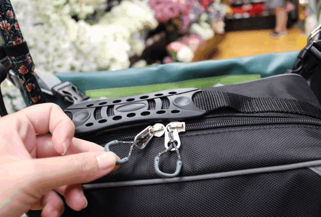 shows a woman's hand pulling the easy-pull zip on the flexi mobility bag