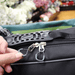 shows a woman's hand pulling the easy-pull zip on the flexi mobility bag