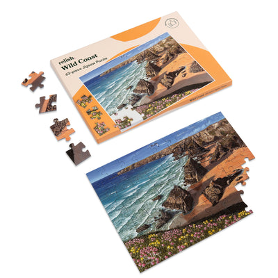 shows a nearly completed wild coast jigsaw puzzle next to the box