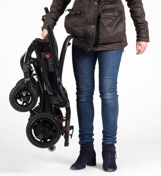 The image shows someone carrying the folded Airfold Powerchair with one hand