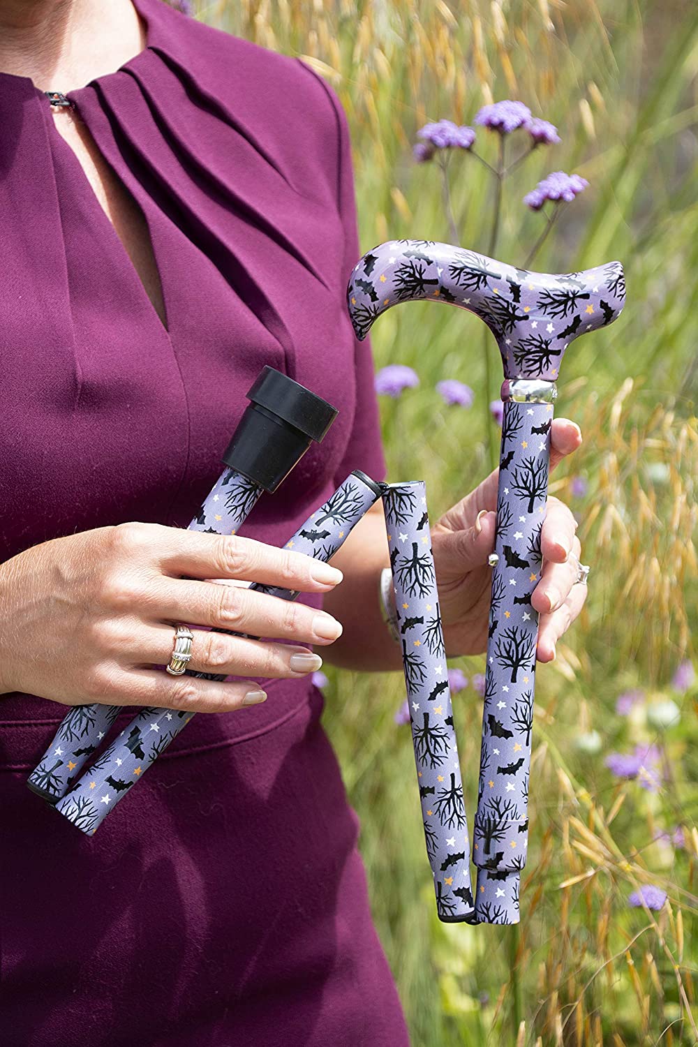 the image shows a woman in a field/overgrown garden, holding a bats at night classic cane