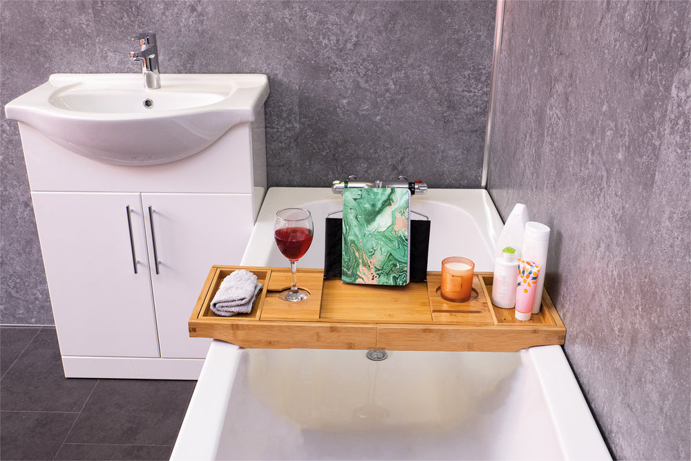 The Bed & Bath Tray Table being used on a bath with a glass of wine, candles, a flannel and a book, on it.
