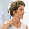 shows someone using an Etac Long Handled Hair Brush