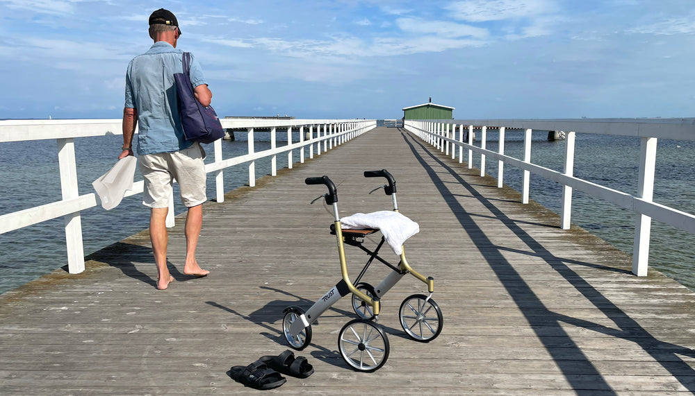 A Let's Go Out Rollator on a promenade on a sunny day.