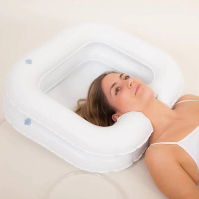 Woman lying down, her head in the Atlantis Deluxe Inflatable Shampoo Ring