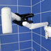 shows the Mobeli Clip Holder with swivel arm attached to a blue tiled wall and holding a portable hair dryer