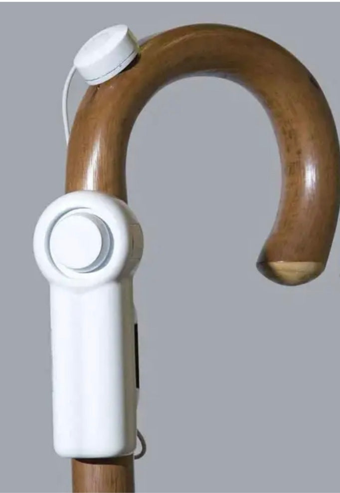 the image shows the mobility and toileting aid alarm attached to a wooden walking stick / cane