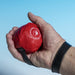 shows a red Trimmy Ball Handi Weight being held in a hand