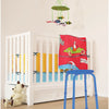 shows a blue multi-purpose adjustable stool in a baby's nursery beside a white cot