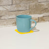 shows a mug resting on a yellow non slip silicone coaster