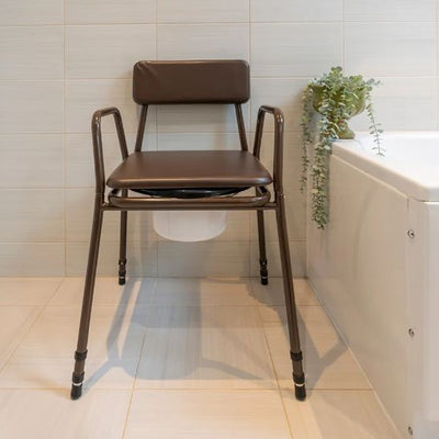 Stackable commode chair in bathroom with lid on
