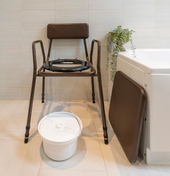 Stackable commode chair in bathroom with lid off