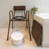 Stackable commode chair in bathroom with lid off