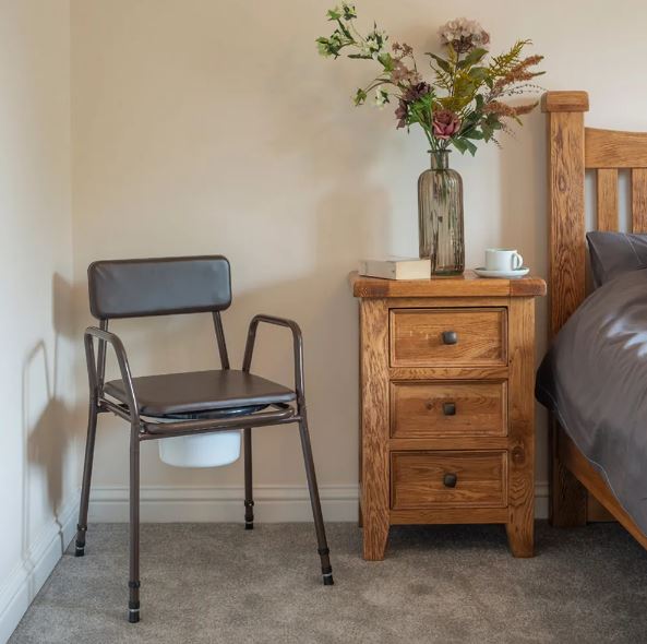 Stackable commode chair in bedroom with lid on