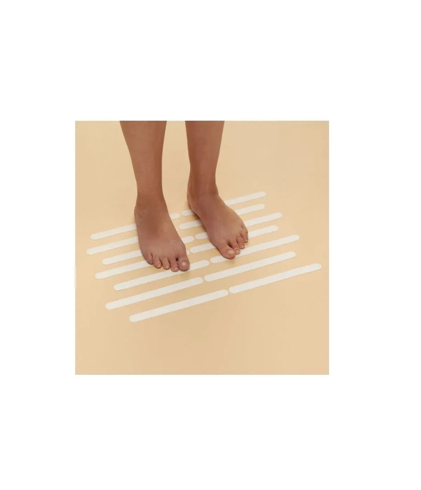 Safety Strips on bathroom floor, person standing on them to demonstrate