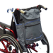 shows the crutch / stick holder bag for wheelchairs, attached to the back of a wheelchair with a folding walking stick / cane in one of the side pockets