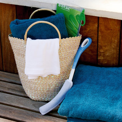 shows an Etac Long Handled Body Washer next to a basket in a bathroom 
