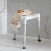 Image shows edge shower stool in the shower, a towel and scrubbing brush are on top of it