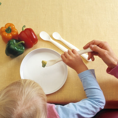 the image shows someone using an etac feeding spoon