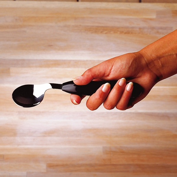shows someone using a right handed Etac Light Angled Spoon