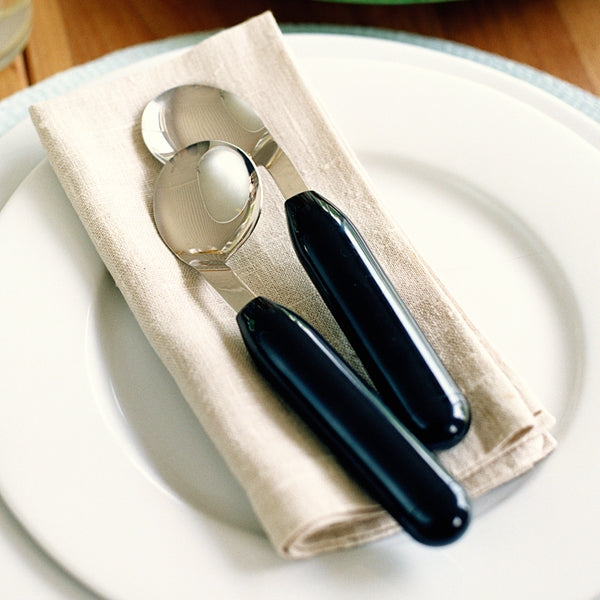shows left and right handed Etac Light Angled Spoons resting on a napkin on a plate