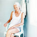 The image shows an older person using an Etac Swift Shower Chair