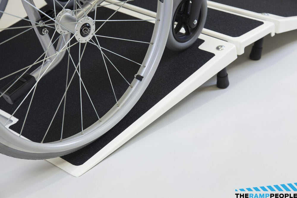 the image shows a close up of a wheelchair using the fibreglass folding threshold ramp